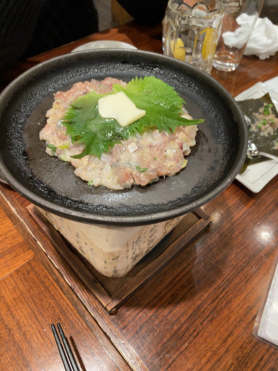 黒い鉄皿に盛られ、大葉がのったさんが焼き